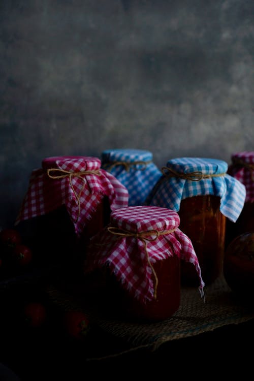 A table with jars of jam and a cloth