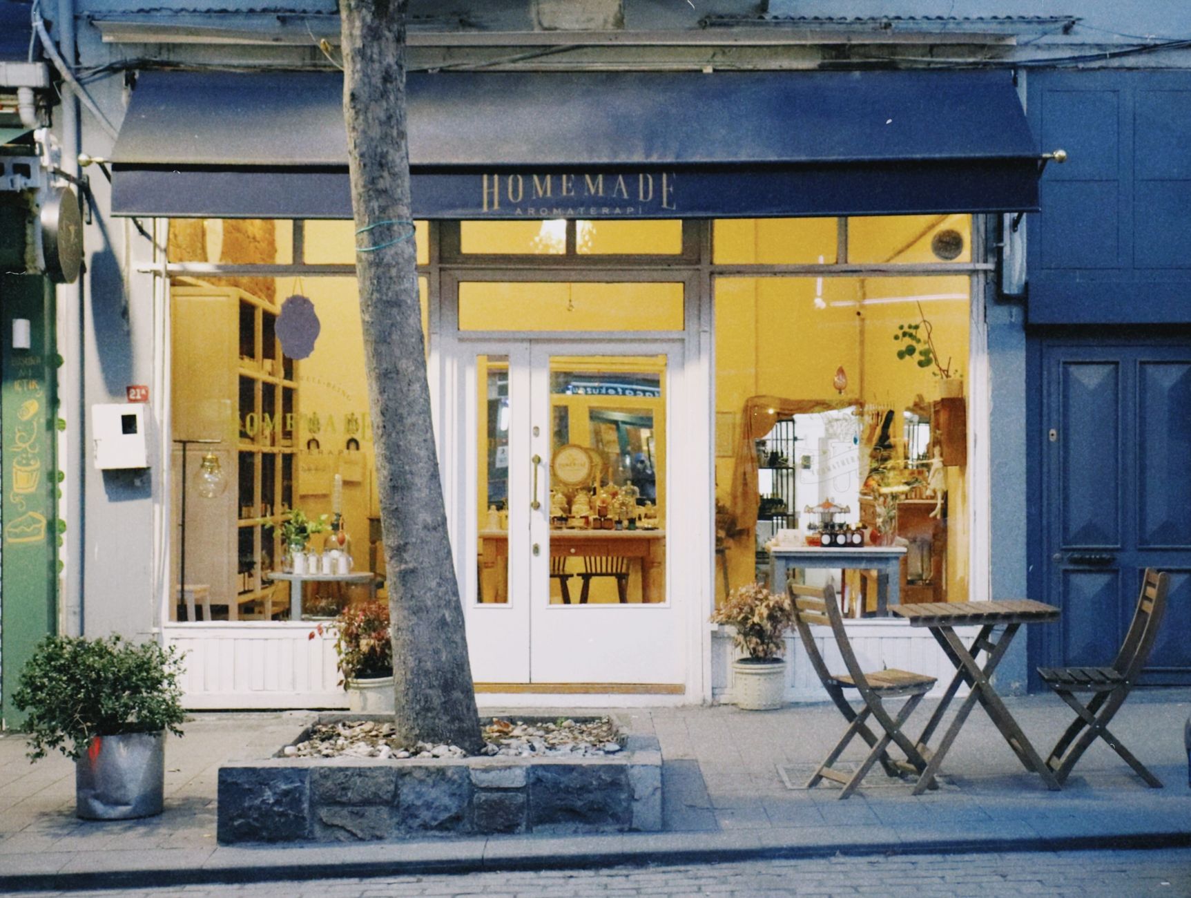 An inviting storefront displaying a cozy café with street seating in an urban setting.