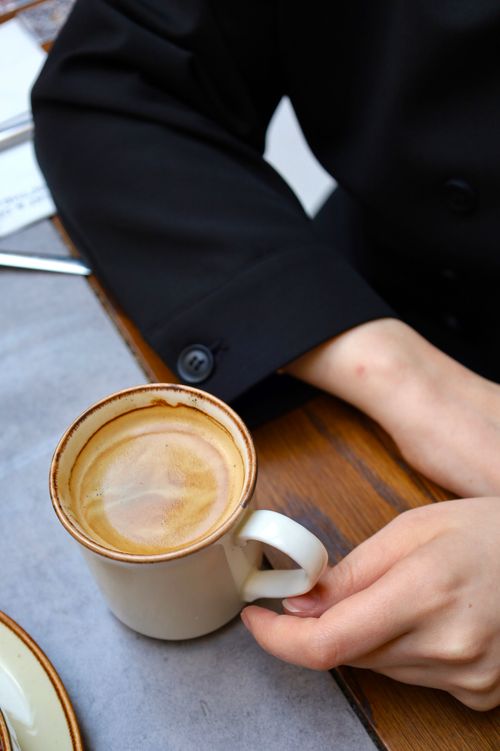 Free Top view of a woman holding a cappuccino in a cafe in Istanbul. Stock Photo
