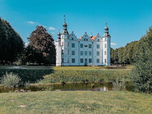 A castle with a pond in the middle of a field