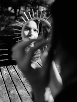 Black and white portrait of a woman holding a mirror outdoors in Lisbon.