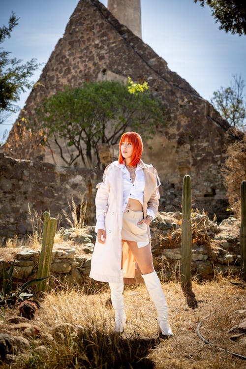 Fashionable Woman in a Skirt, Boots and a Trench Standing Outside 