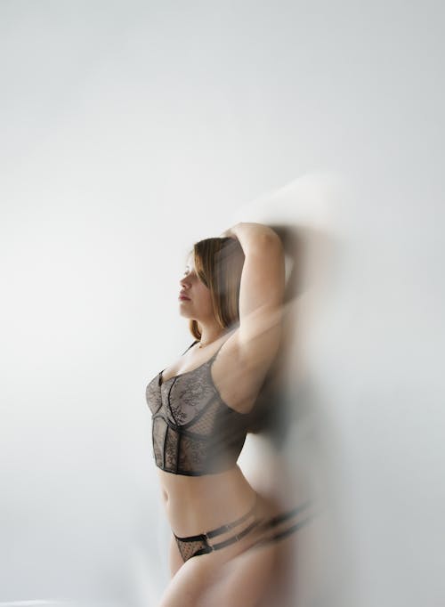 A woman in lingerie posing in front of a mirror