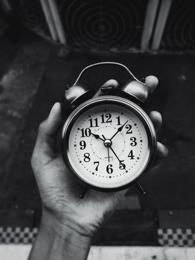 Hand holding a wall clock (photo: Ammar Khan on Pexels)