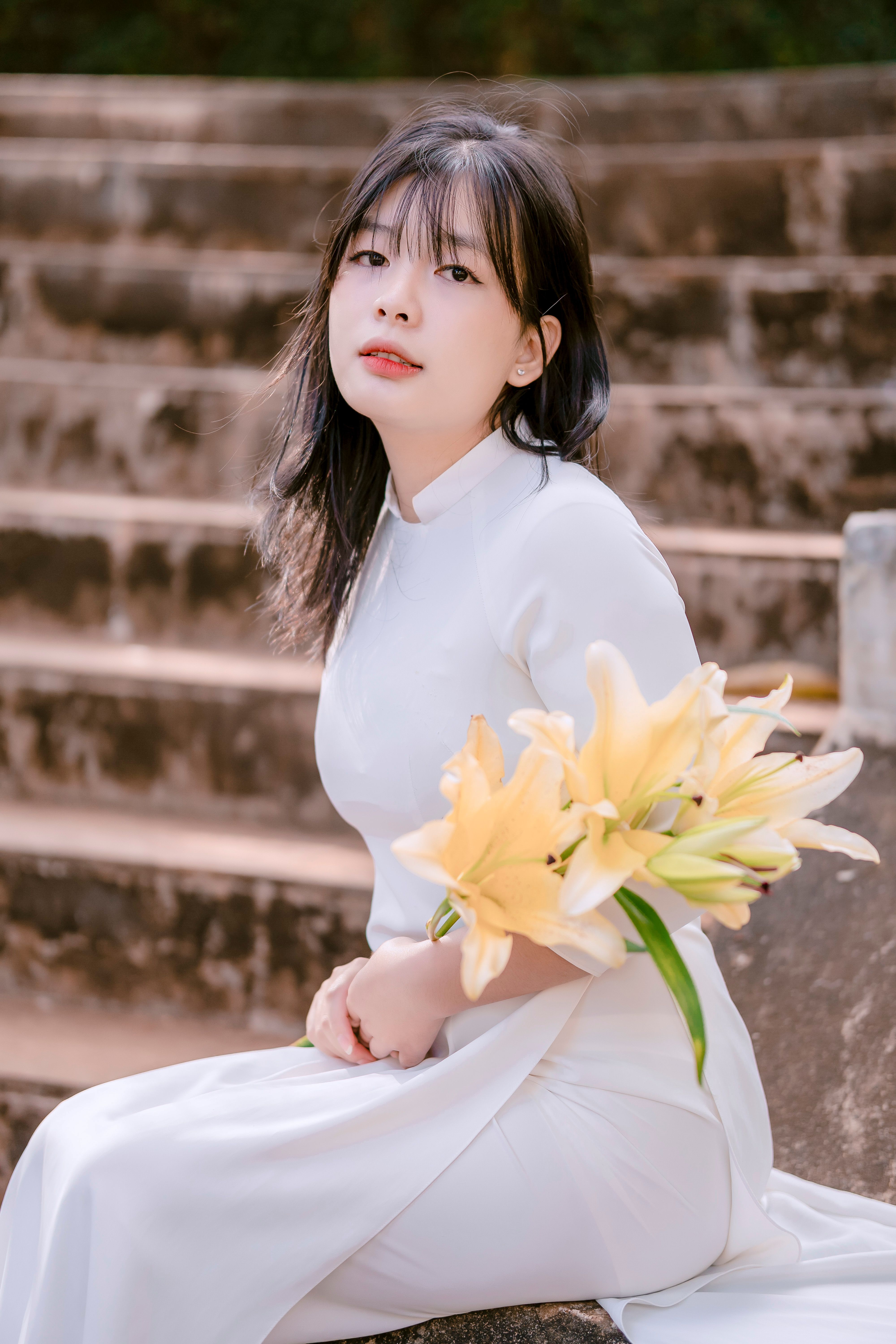 Woman in White, Traditional Dress Sitting with Flowers · Free Stock Photo