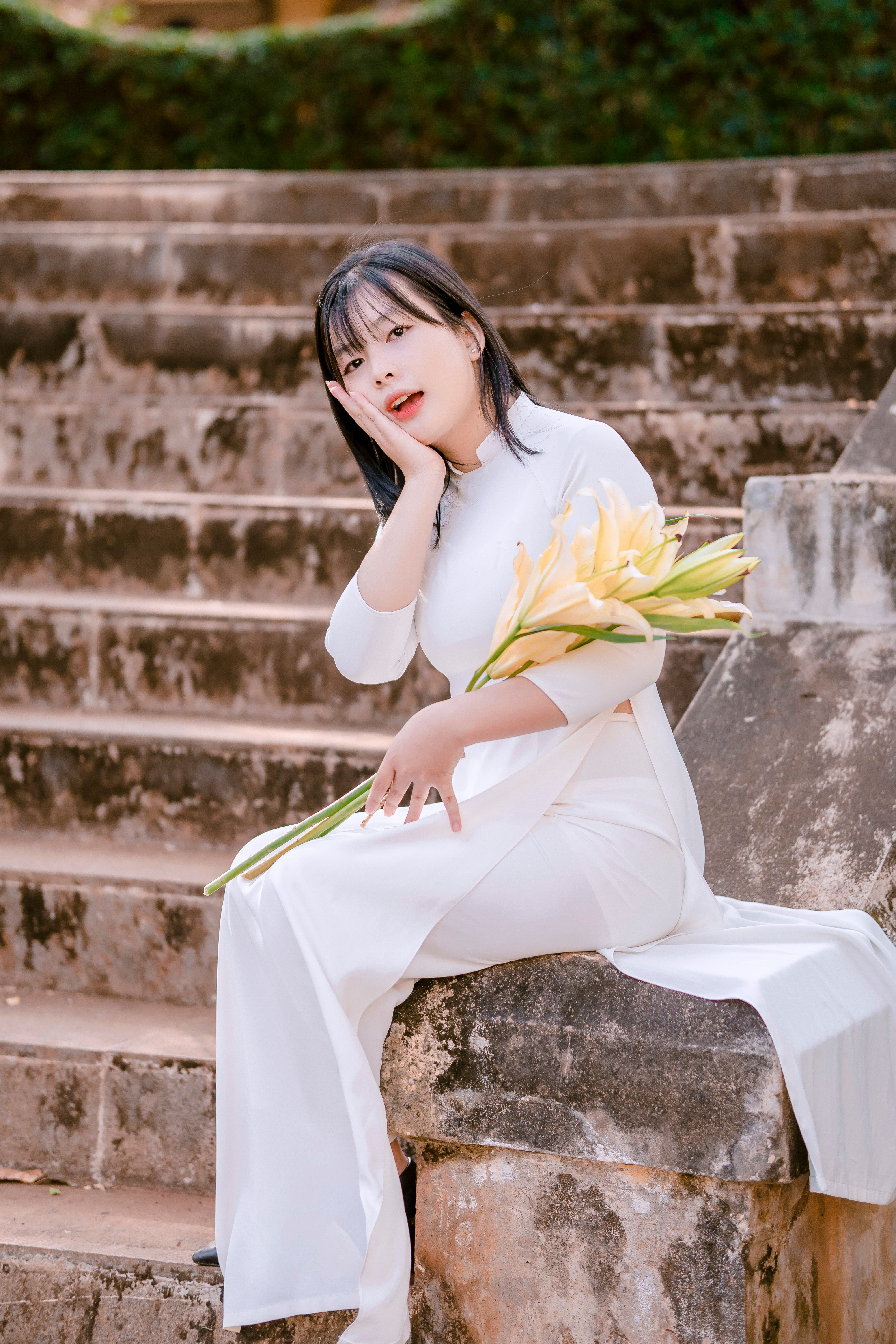 Woman in White, Traditional Dress Sitting with Flowers · Free Stock Photo