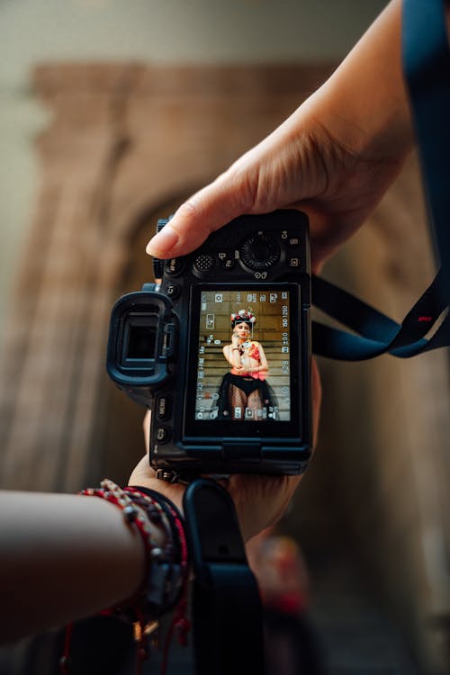 A person holding a camera with a photo of a woman