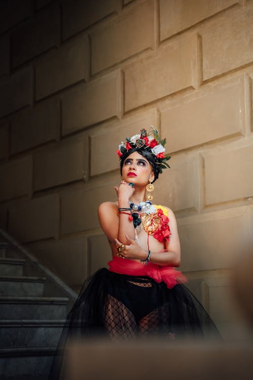 A woman in a black and red dress with flowers on her head