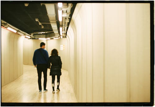 A couple walking down a hallway in a building