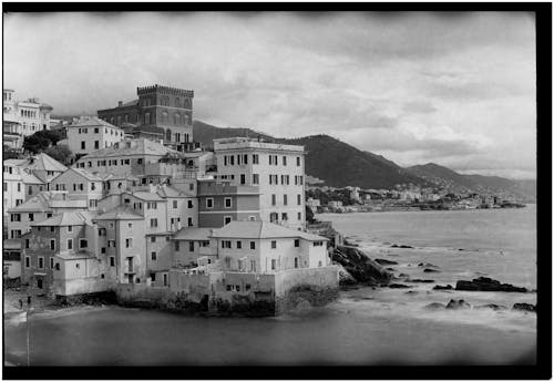 A black and white photo of a town by the sea