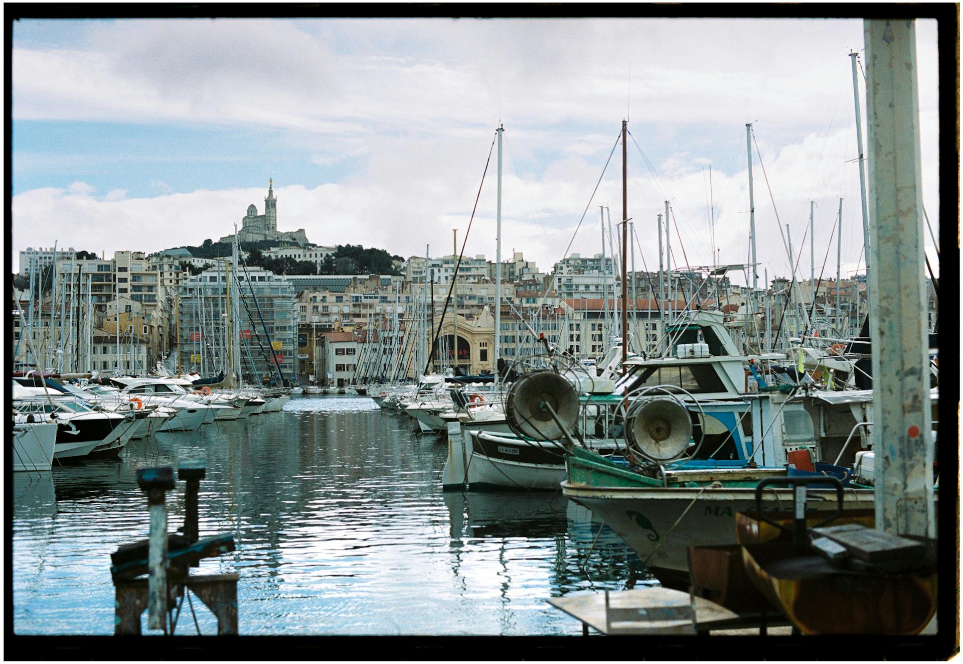 Explore the charming Old Port of Marseille with moored boats and a cityscape backdrop.