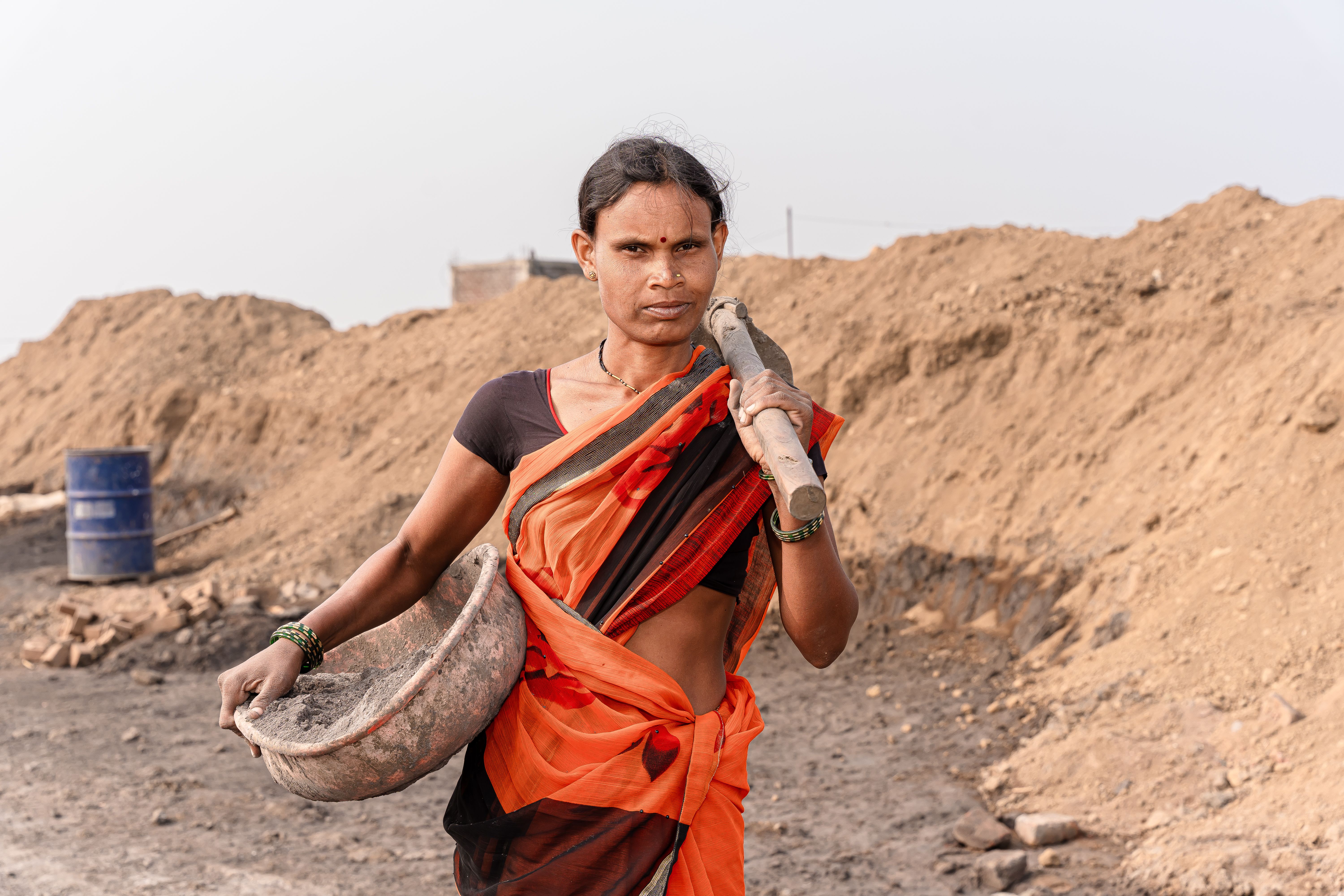 Imajen hatudu traballador rural iha India ne'ebé hetan impaktu husi lei foun VB-GRAMG, ho bandeira India no simbolu servisu r