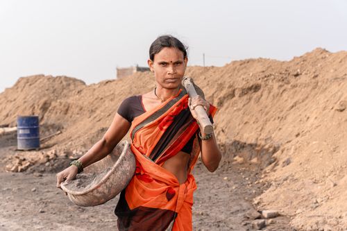 Free A South Asian woman carrying construction materials outdoors in rural Nagpur, India. Stock Photo