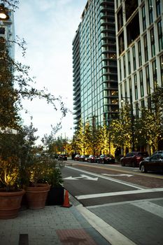Scenic urban street with cars and high-rise buildings at dusk.
