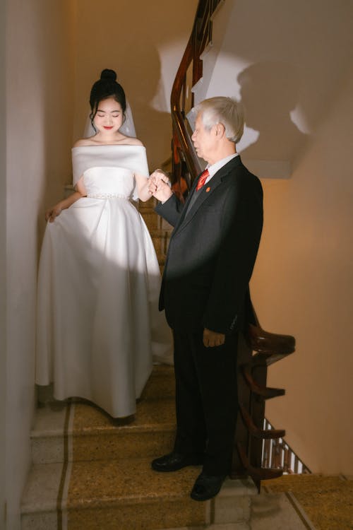 A man and woman in formal attire standing on stairs