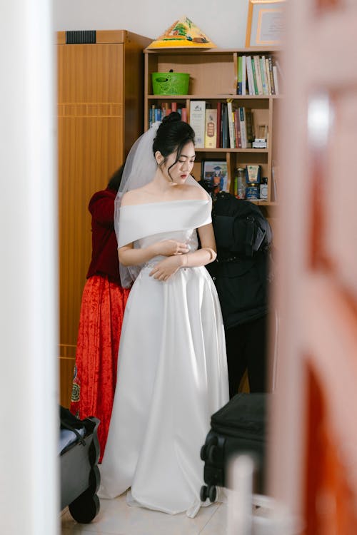 A bride in a wedding dress is standing in a room