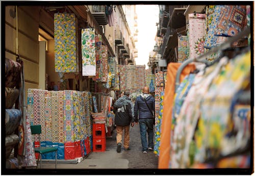 A street with people walking through it and colorful fabric