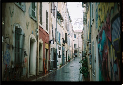 A narrow alley with graffiti on the walls