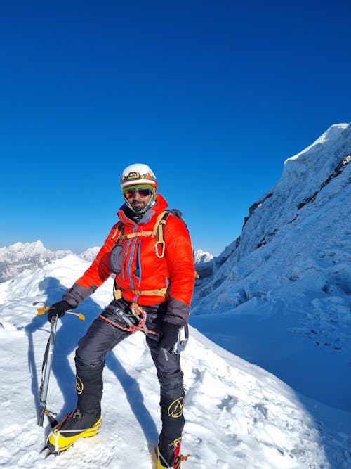 Man Standing on Snow in Mountains