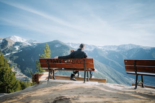 Father with Child Sitting on Bench in Mountains