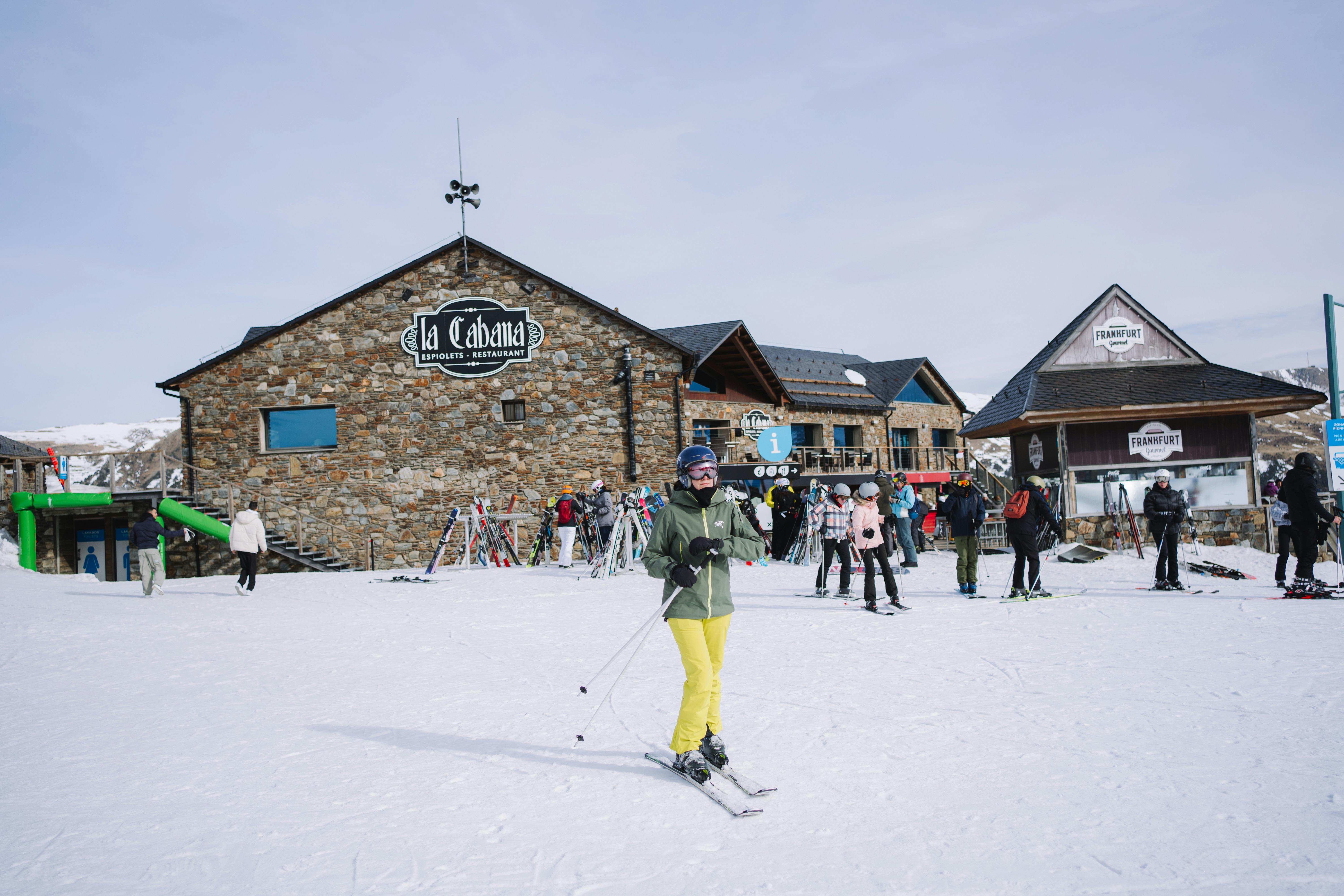 Prescription Goggle Inserts - Skiers in a vibrant winter setting at La Cabaña, surrounded by snow-covered slopes and lively atmosphere.