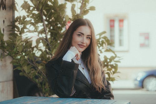 A woman sitting at a table in front of a tree