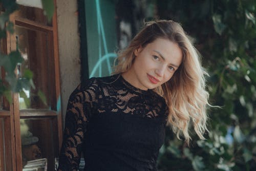 A woman in a black lace dress posing for a photo