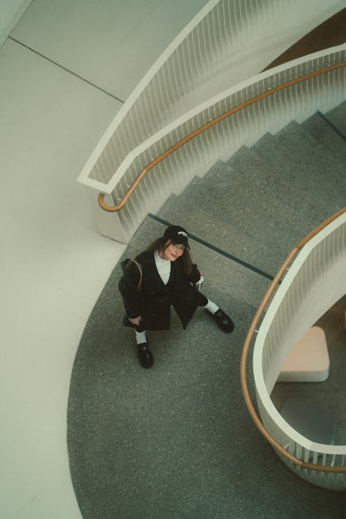 A person standing on the stairs of a spiral staircase