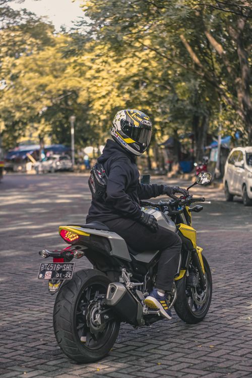 Free Motorcyclist riding through city street, showcasing urban lifestyle with a modern motorbike. Stock Photo