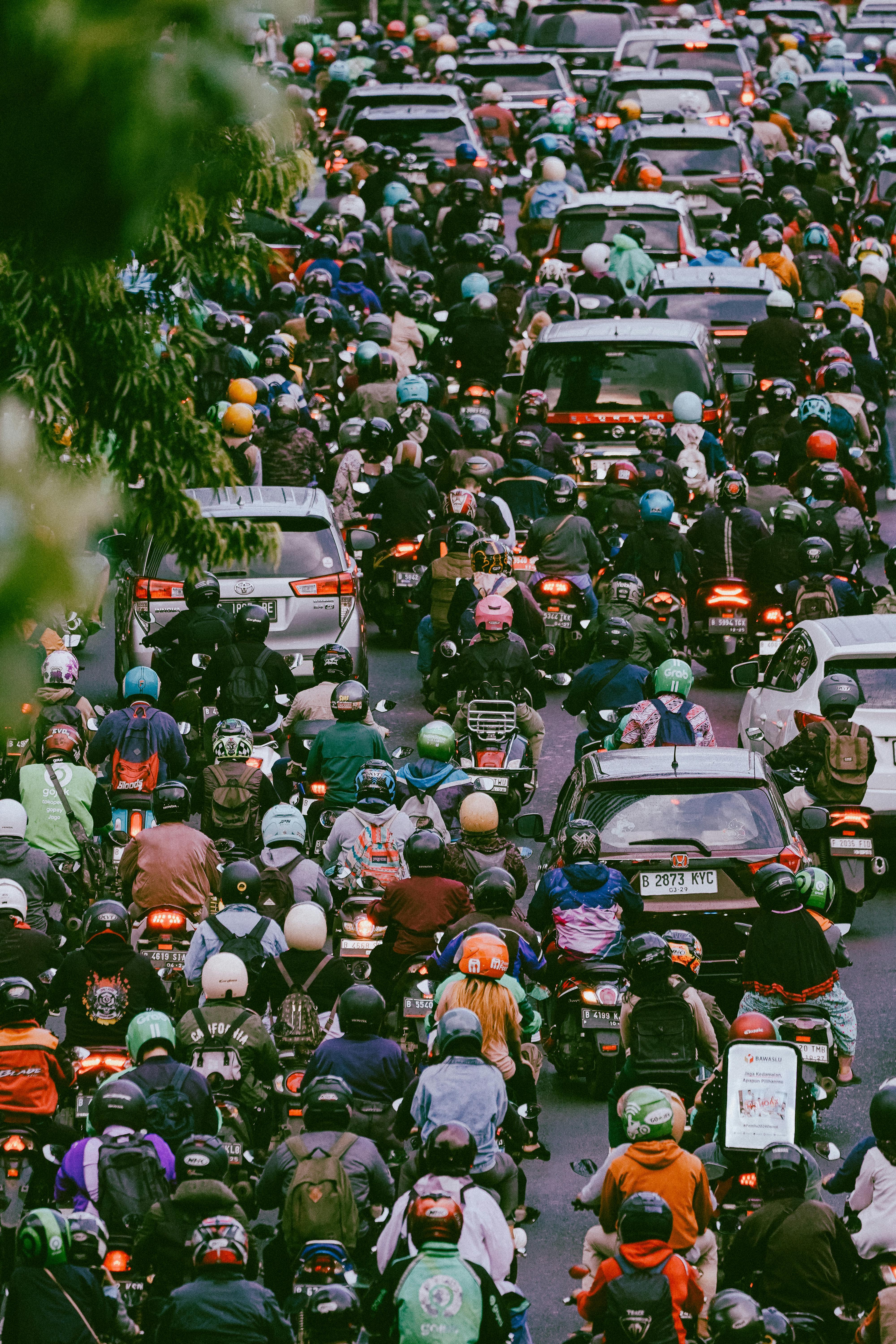 Heavy motorcycle and car traffic in Jakarta during rush hour captured from above.