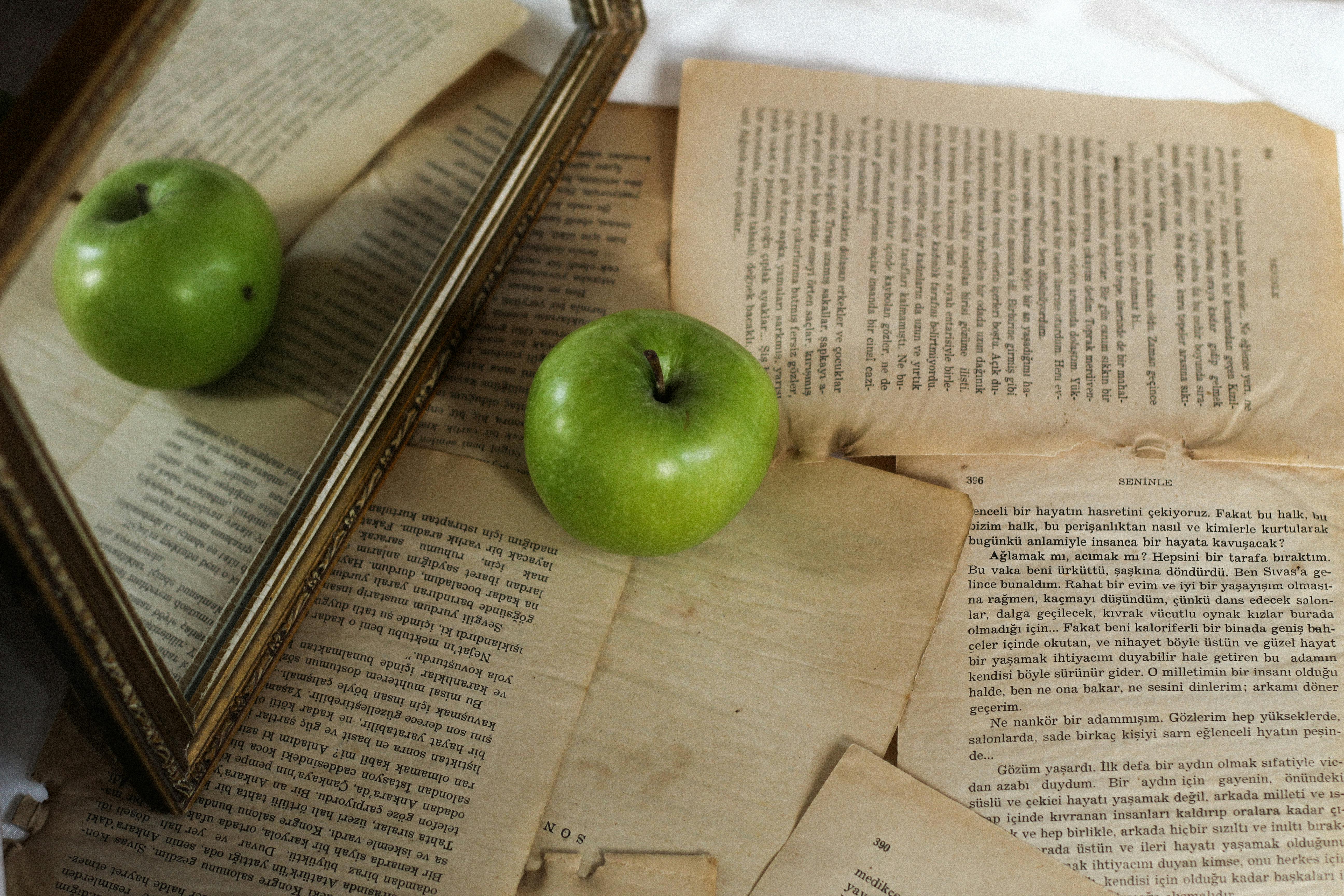 A green apple sitting on top of a book