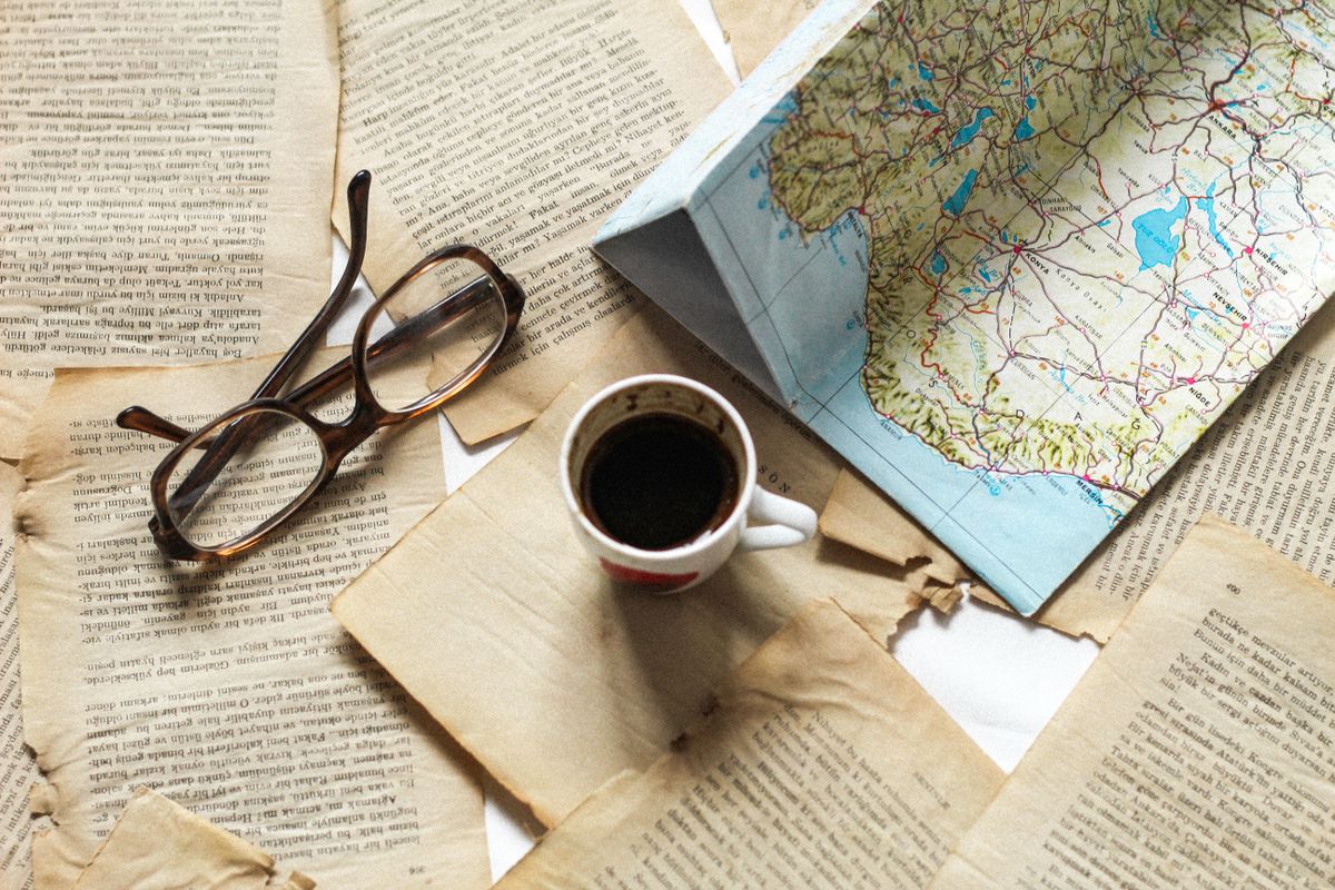 Hartii ingalbenite, ochelari, cafea si o harta rutiera pliata