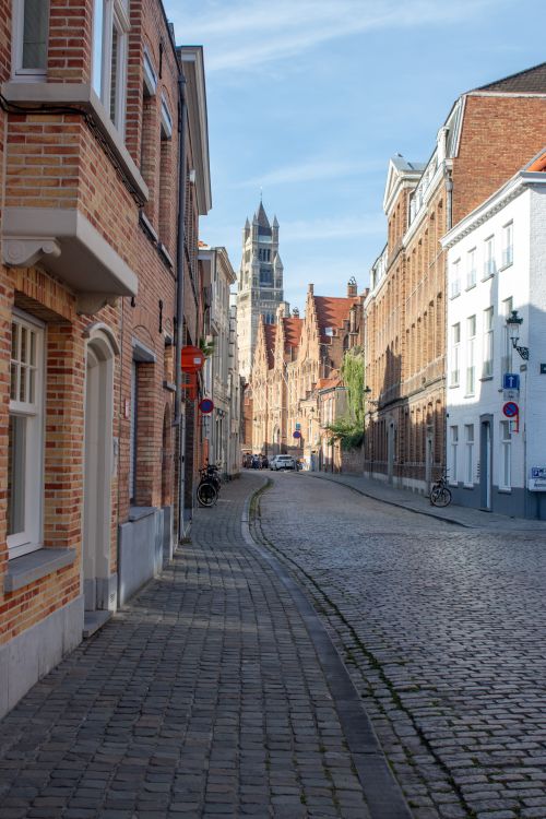 Free View of a picturesque cobblestone street lined with historic buildings in Bruges, Belgium. Stock Photo