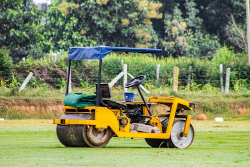 A yellow and green lawn mower on a field