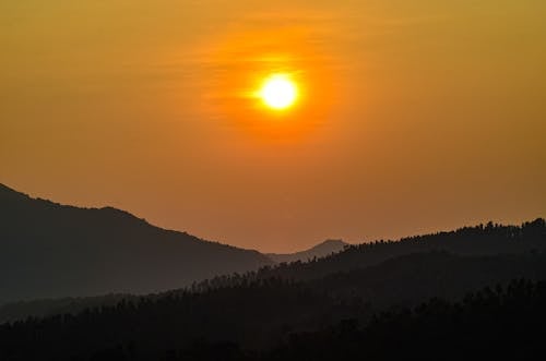 The sun is setting over a mountain range