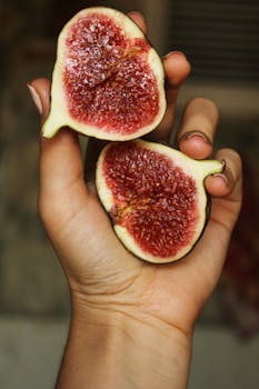 Close-up shot of fresh figs in hand, showcasing vibrant colors and natural texture.