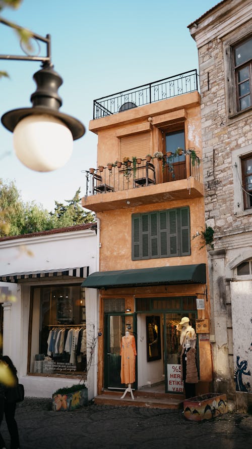 A building with a balcony and a lamp on the street