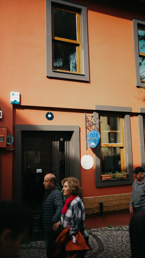 A group of people walking down a street in front of a building