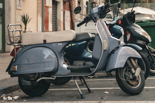 Free A blue vintage motor scooter parked in Syracuse, Sicily's urban streets. Stock Photo
