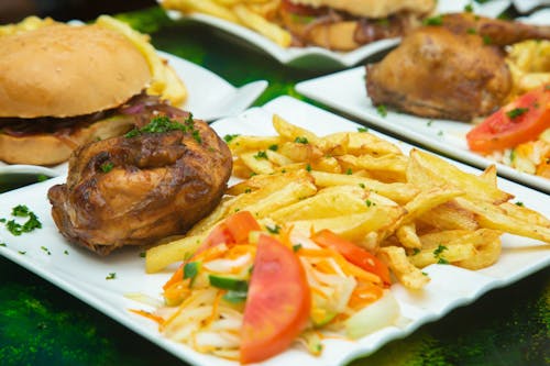 A plate of food with french fries, chicken and coleslaw