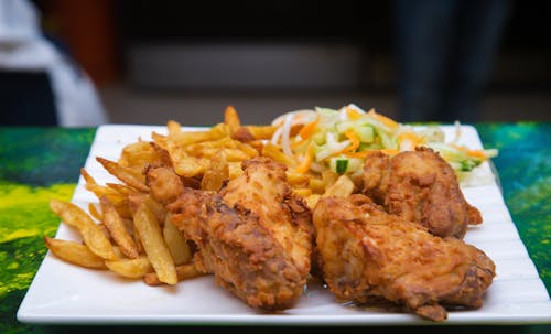 A plate of fried chicken and fries on a table