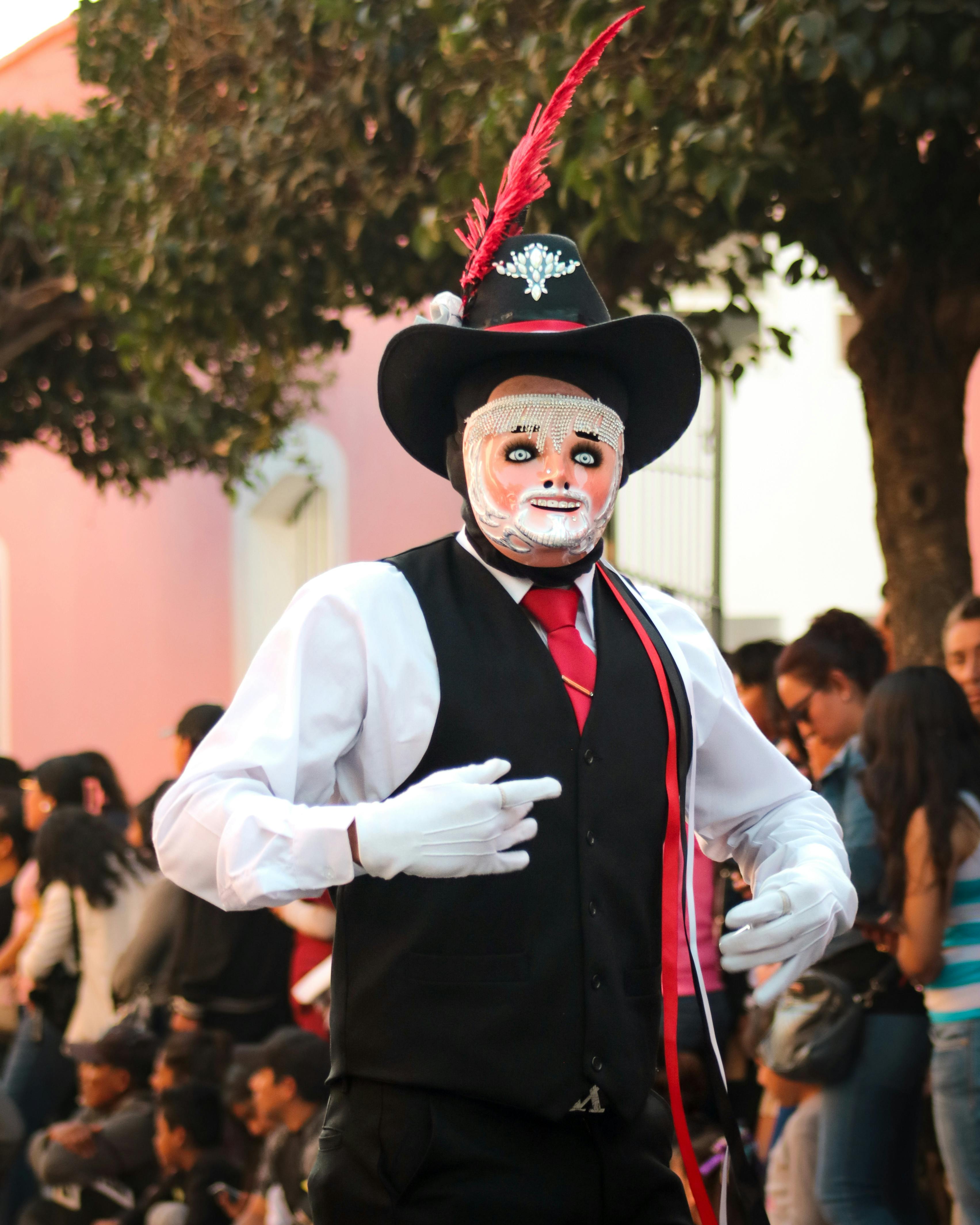 Man in traditional costume and mask performing at an outdoor festival.
