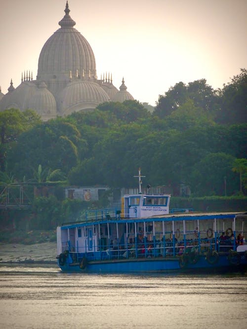 A boat is traveling down a river with a large dome in the background