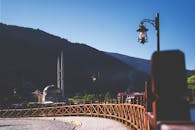 群山之中，清真寺风景如画，蔚蓝的天空下矗立着老式灯柱