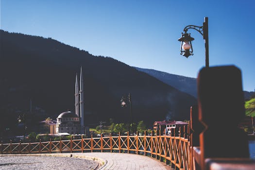 群山之中，清真寺风景如画，蔚蓝的天空下矗立着老式灯柱