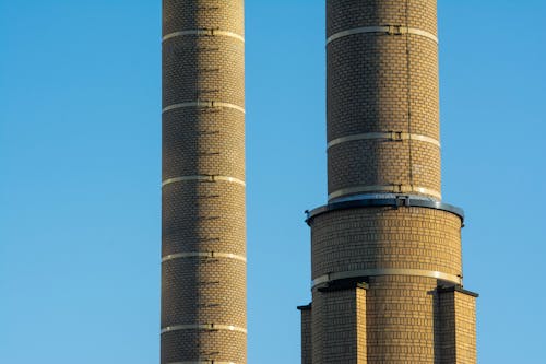 Two chimneys with smoke coming out of them