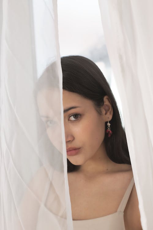 Brunette Woman behind Curtain