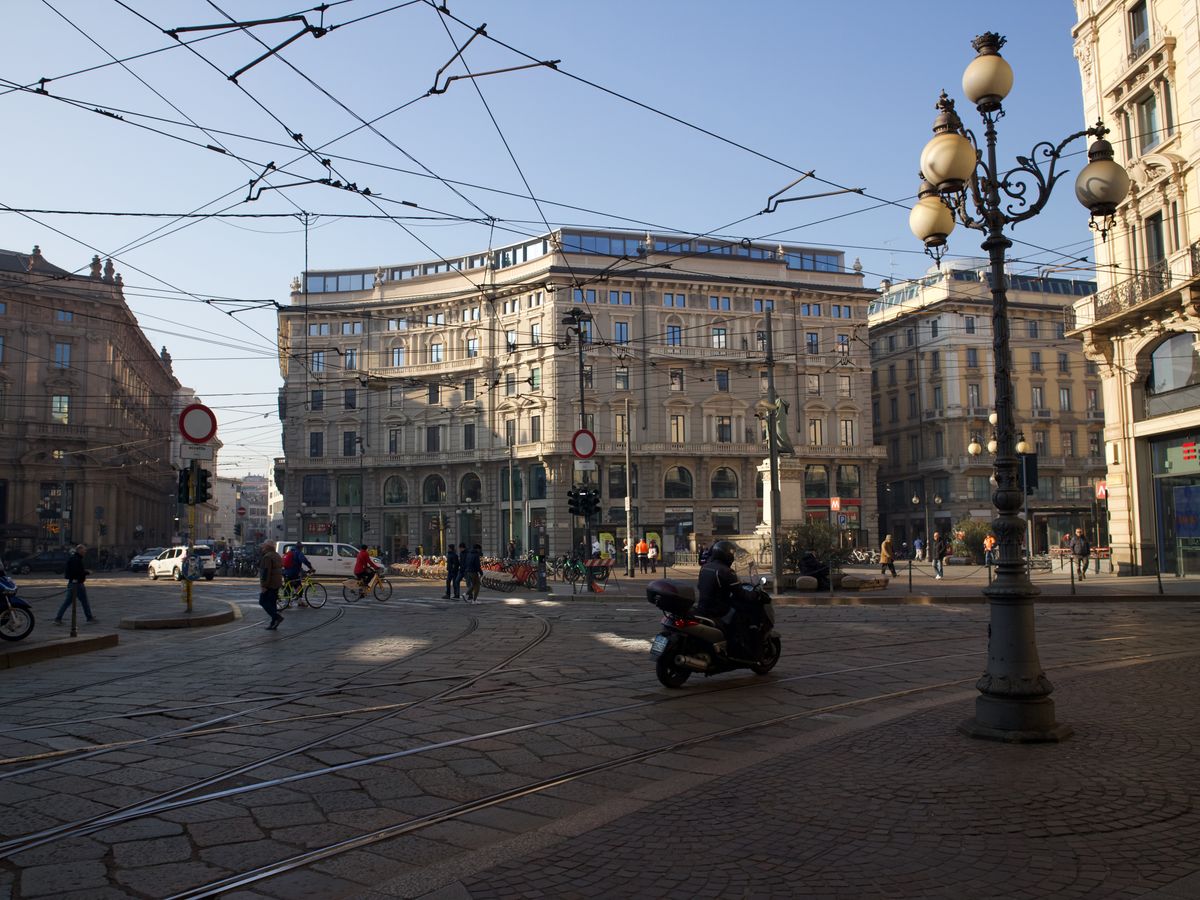 Intersecție aglomerată din centrul Milanului, cu scutere și pietoni