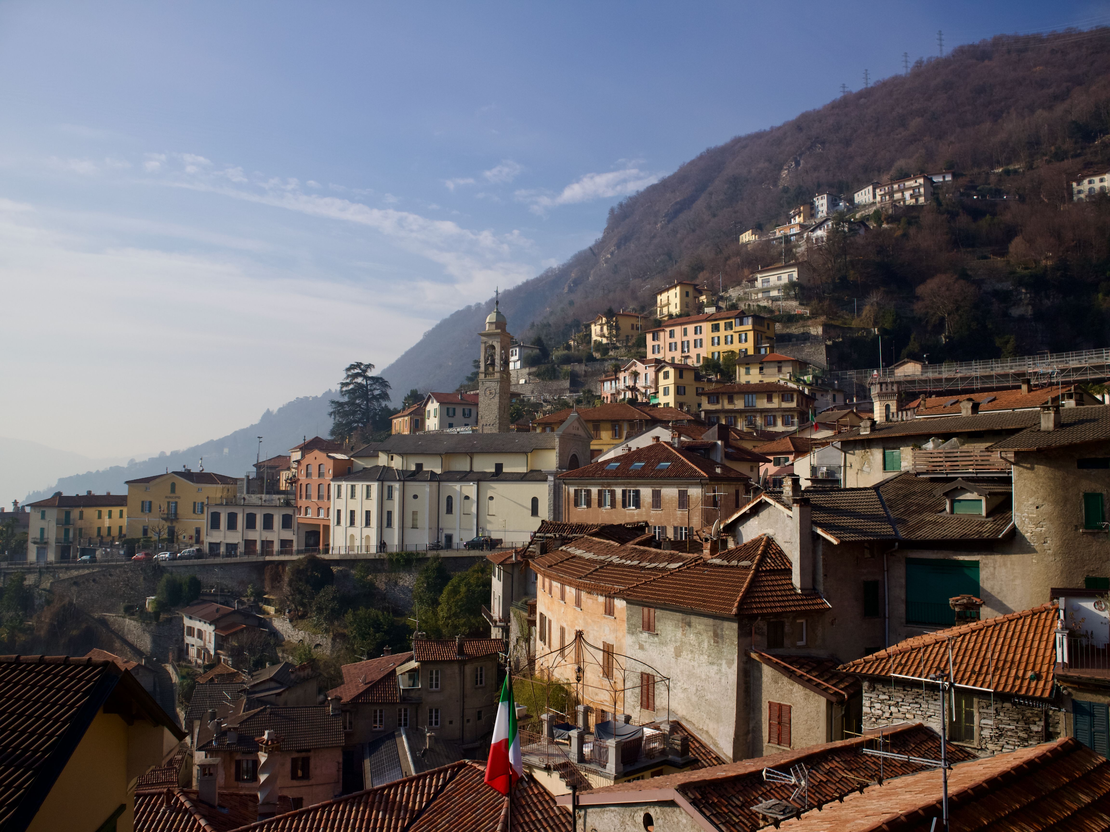Picturesque hillside village in Italy with traditional houses and church, captured during daytime.