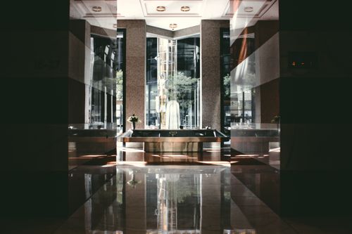 Free A sophisticated modern hotel lobby with glossy floors and natural light entering through large windows. Stock Photo